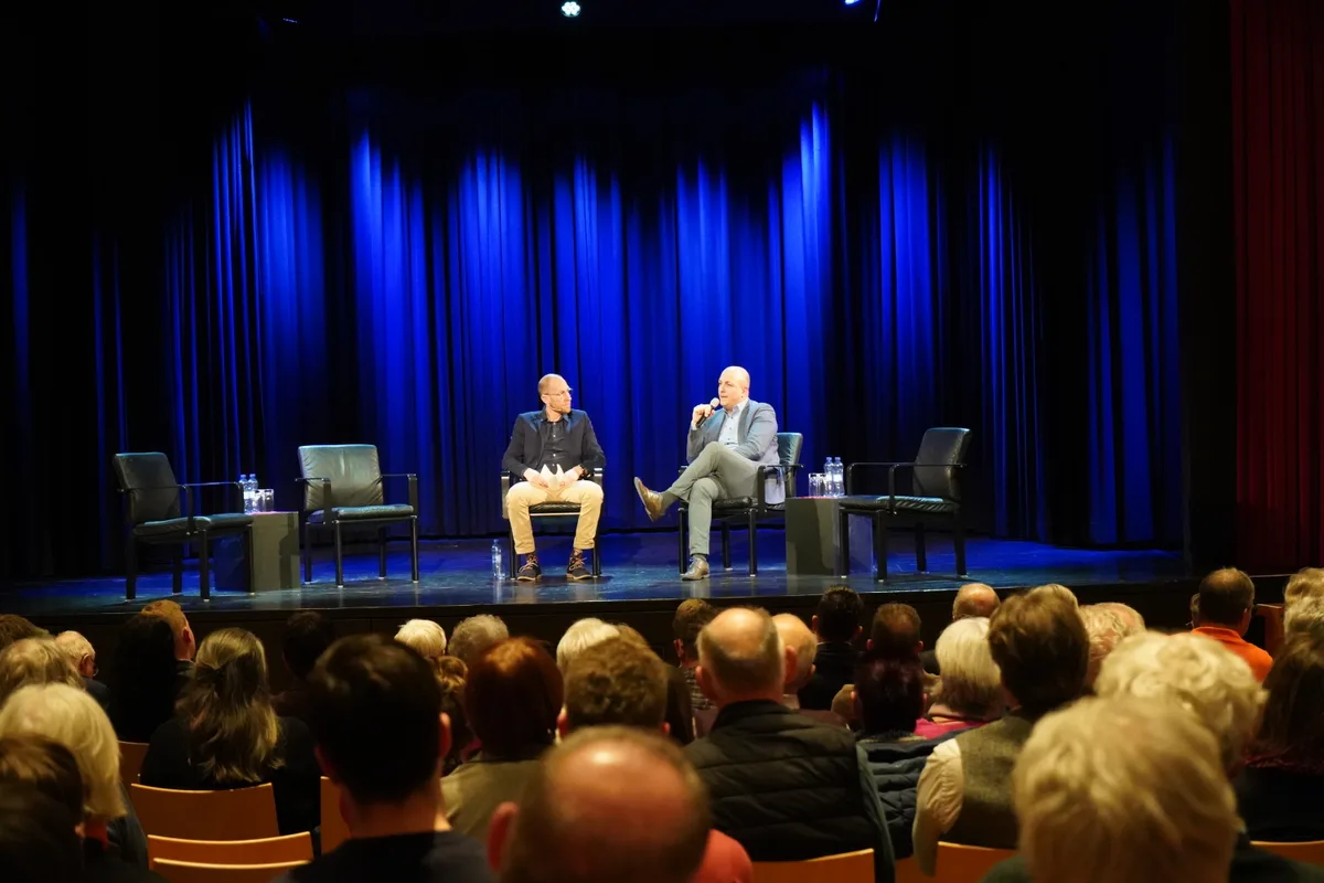 Politikerinnen und Politiker sind auf der Bühne und beantworten Fragen.